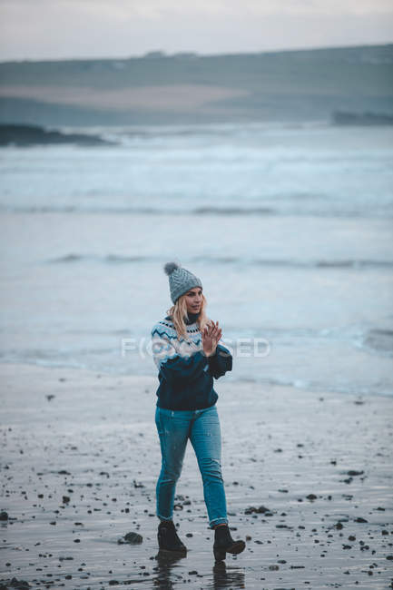 Femme marchant sur une plage au crépuscule — Photo de stock