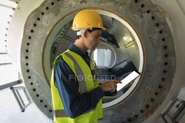 Trabajador masculino atento usando tableta digital en la estación solar - foto de stock