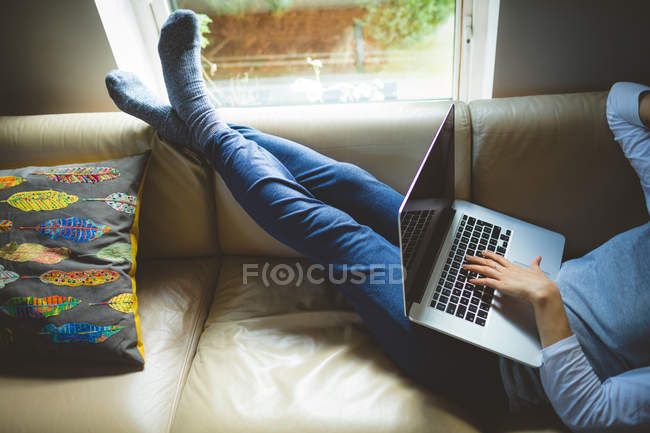 Frau benutzt Laptop im heimischen Wohnzimmer — Stockfoto
