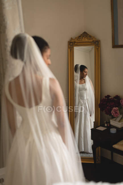 Отражение молодой невесты в свадебном платье в зеркале — стоковое фото