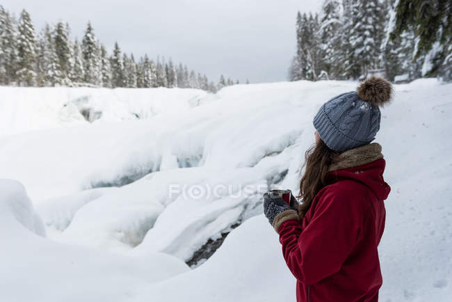 Mulher tomando café em uma paisagem nevada durante o inverno — Fotografia de Stock