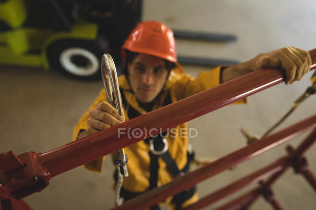 Young male worker climbing scaffolding at solar station — Stock Photo