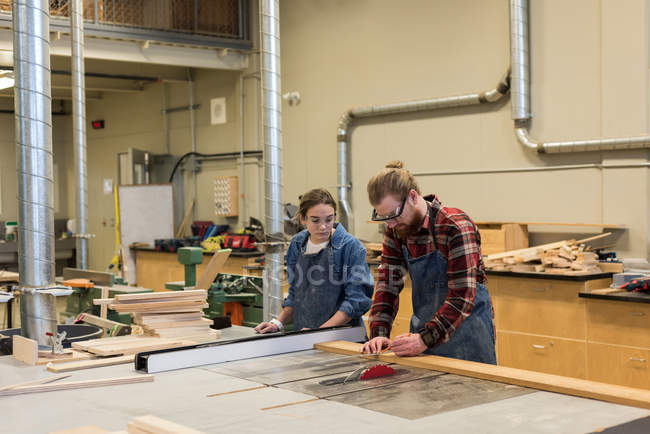 Male and female carpenters working together at workshop — Stock Photo