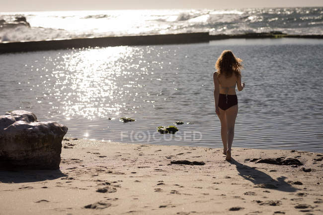 Задній вид жінка в бікіні стоїть біля моря — стокове фото