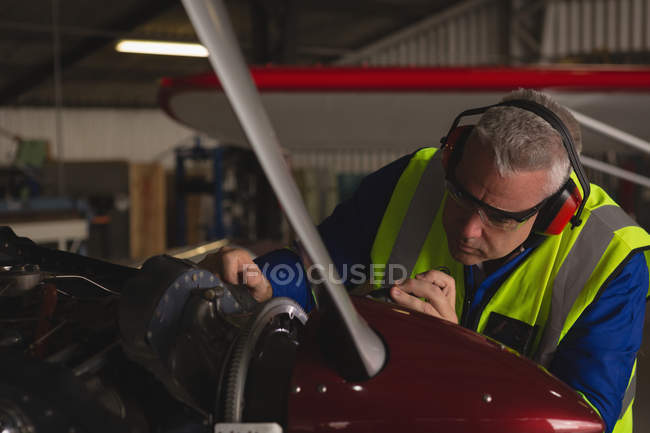 Ingenieur repariert Flugzeugmotor im Hangar — Stockfoto