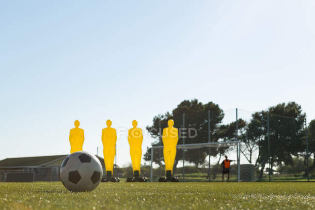 Футбольное снаряжение и футбольный мяч в поле в солнечный день — стоковое фото