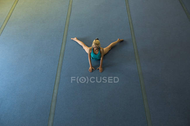 Desportista realizando exercício de alongamento no estúdio de fitness — Fotografia de Stock