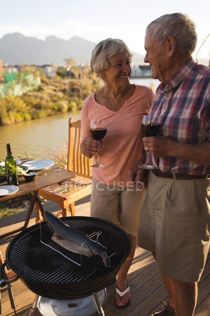 Felice coppia anziana avendo vino nel cortile — Foto stock