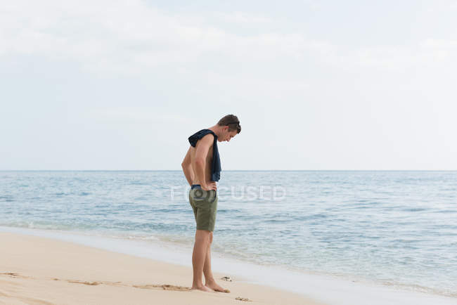 Hombre de pie en la playa - foto de stock