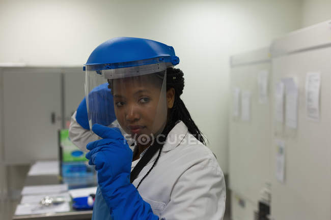 Female scientist wearing safety helmet in science lab — Stock Photo