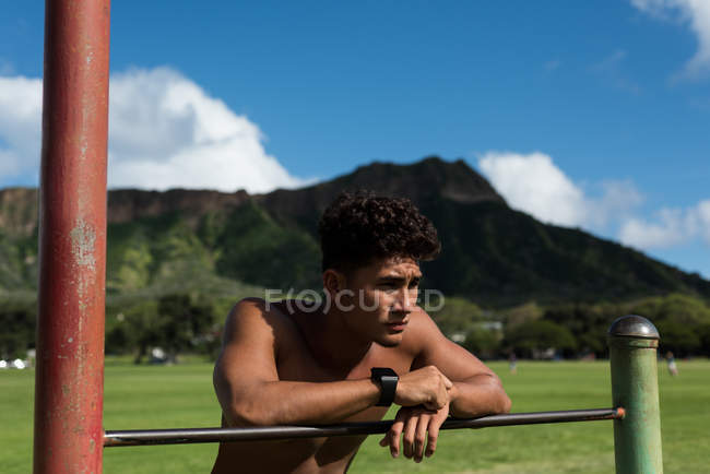 Jeune homme faisant une pause tout en faisant de l'exercice dans le parc — Photo de stock