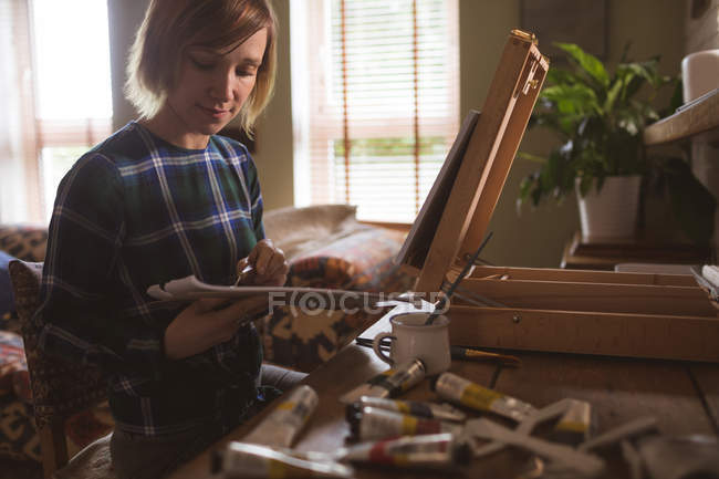Peinture d'artiste féminine sur toile dans le salon à la maison — Photo de stock