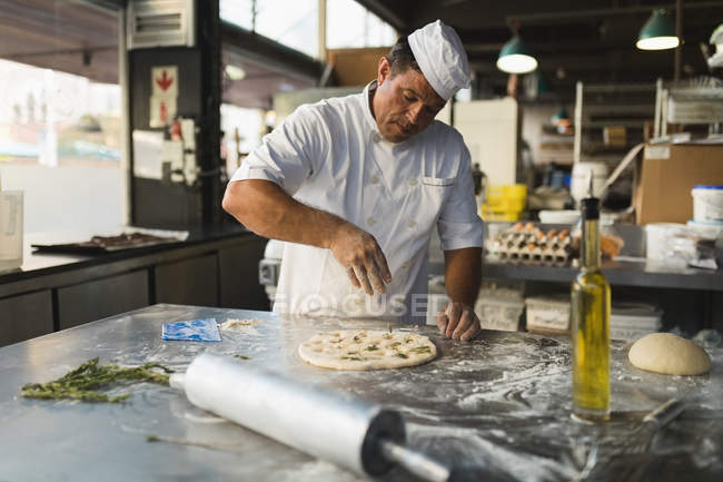 Reifer Bäcker bereitet Teig in Bäckerei zu — Stockfoto