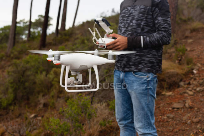 Hombre operando un dron volador - foto de stock