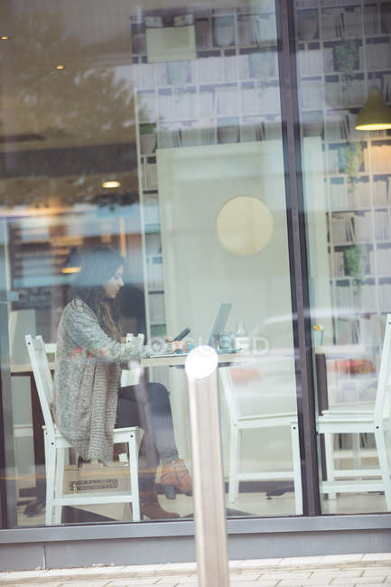 Молода жінка, використовуючи ноутбук у кафе — стокове фото