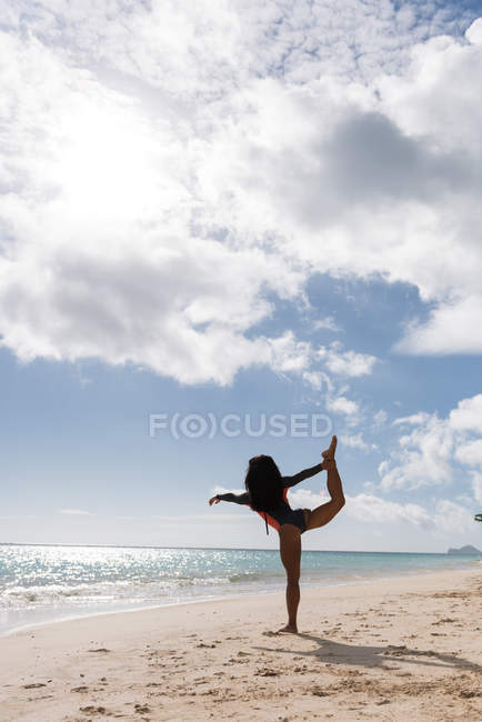Donna che si allena in spiaggia in una giornata di sole — Foto stock