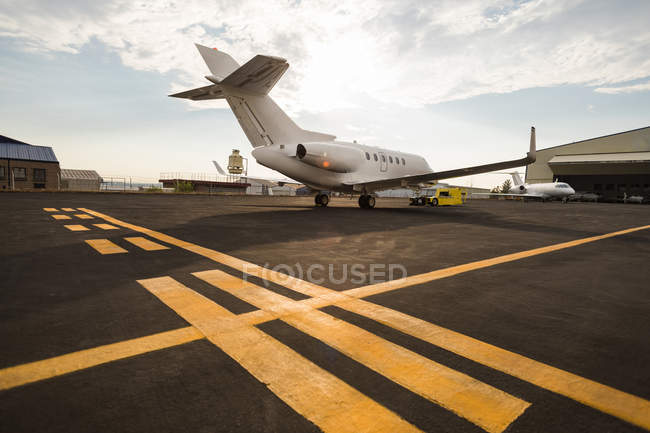 Jet privado con carro en la terminal en un día soleado - foto de stock