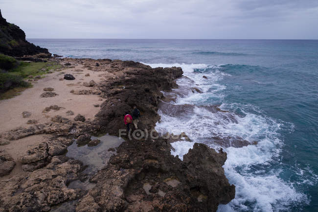 Tourist walking on the rocky coast near the sea — Stock Photo