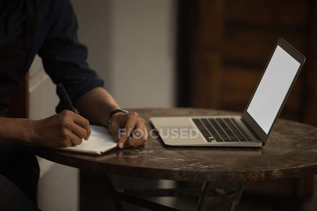 Gros plan d'un homme d'affaires écrivant sur un journal intime dans un café — Photo de stock