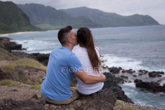 Vista trasera de la pareja abrazándose cerca del mar - foto de stock