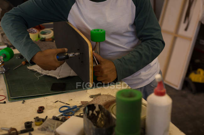 Mid section of man making skateboard in workshop — Stock Photo