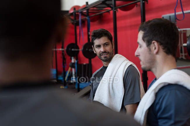 Freunde diskutieren miteinander im Fitnessstudio — Stockfoto