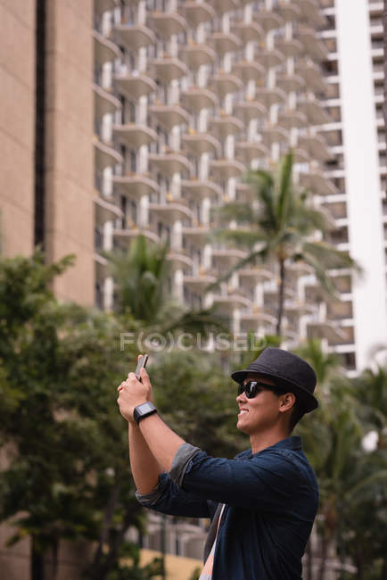 Чоловік натискає фотографію з мобільним телефоном у місті — стокове фото