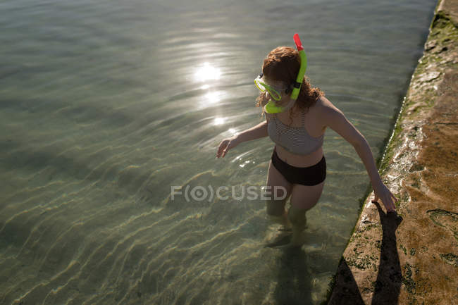 Femme debout dans la piscine par une journée ensoleillée — Photo de stock