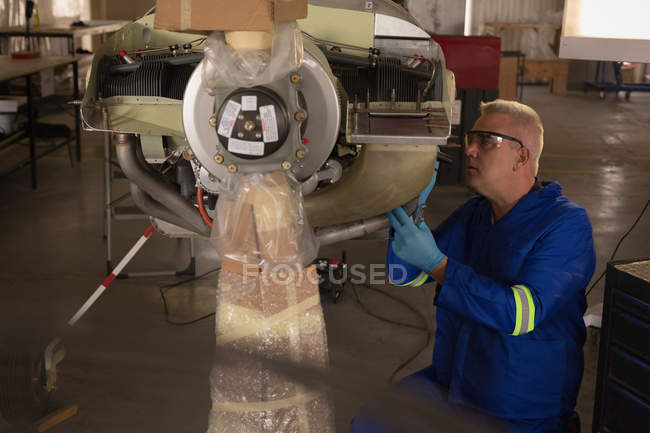 Ingenieur überprüft Flugzeugteile in Aufhängung — Stockfoto