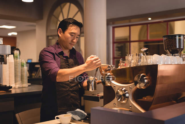 Чоловічий офіціант готує каву в кав'ярні — стокове фото