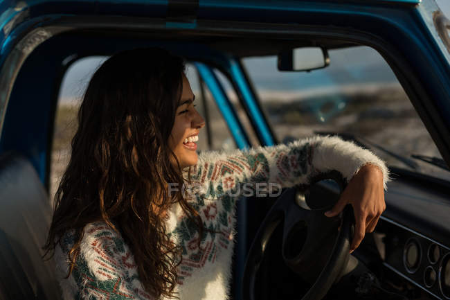 Femme heureuse assise dans une camionnette — Photo de stock