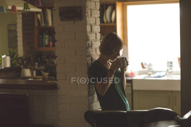 Bella donna che ha una tazza di caffè a casa — Foto stock