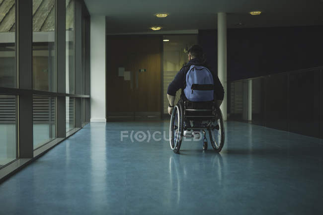Gehbehinderter Rollstuhlfahrer bewegt sich in Durchgang an Turnhalle — Stockfoto