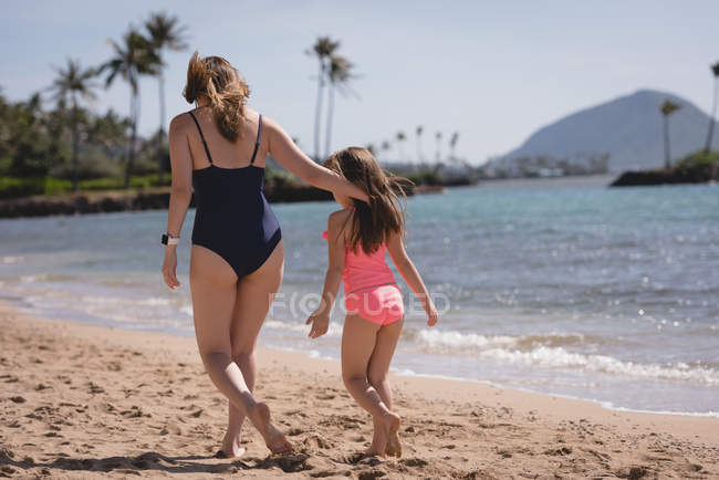 Мать и дочь гуляли вместе на пляже в солнечный день — стоковое фото