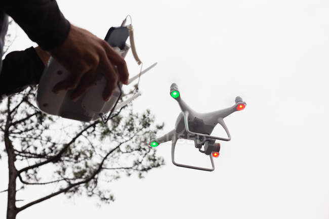 Homme conduisant un drone volant dans la campagne — Photo de stock
