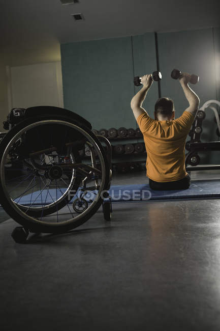 Інвалідний чоловік займається з гантелі в спортзалі — стокове фото