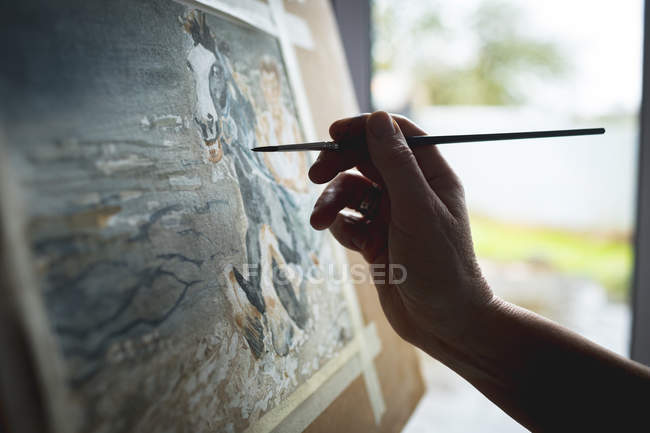 Hand of female artist painting picture on canvas at home — Stock Photo
