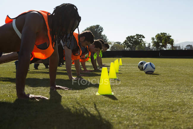 Players doing push up in the field on a sunny day — Stock Photo