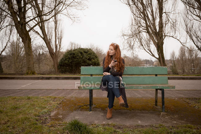 Beautiful woman using mobile phone in countryside — Stock Photo