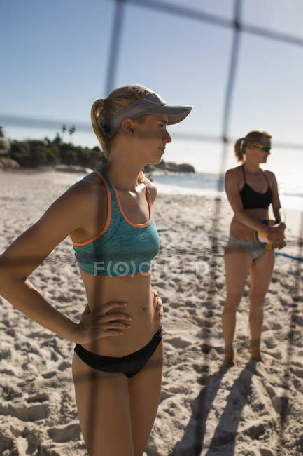 Junge Volleyballerinnen stehen am Strand — Stockfoto
