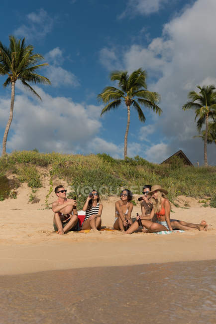Groupe d'amis s'amuser à la plage par une journée ensoleillée — Photo de stock