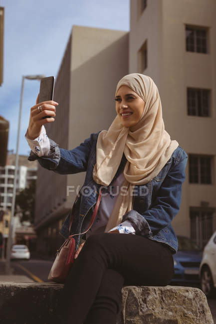 Beautiful urban hijab woman taking selfie with mobile phone — Stock Photo