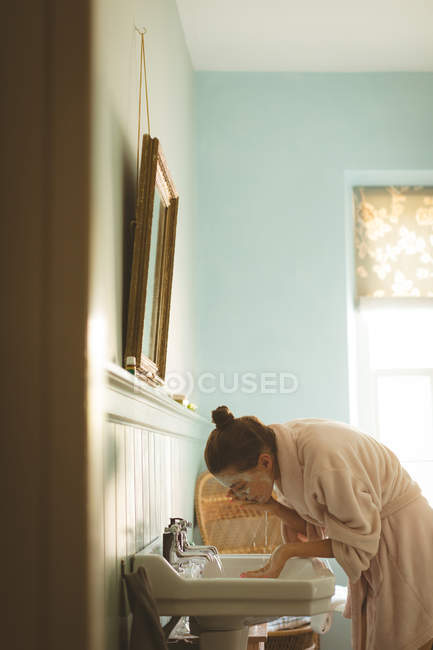 Mulher lavando o rosto no banheiro em casa — Fotografia de Stock