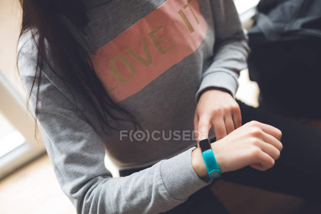 Mid section of female dancer using smartwatch in dance studio — Stock Photo