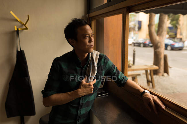 Homem atencioso olhando através da janela no café — Fotografia de Stock