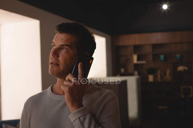 Бизнесмен разговаривает по мобильному телефону в кафе в офисе — стоковое фото