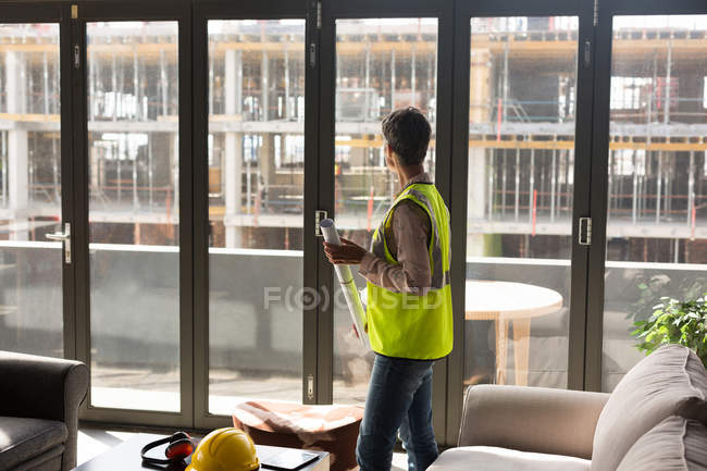 Female architect holding blueprint in the office — Stock Photo