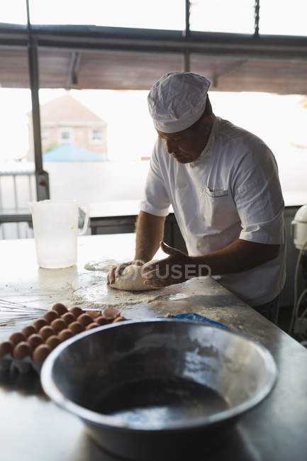 Reifer Bäcker bereitet Teig in Bäckerei zu — Stockfoto