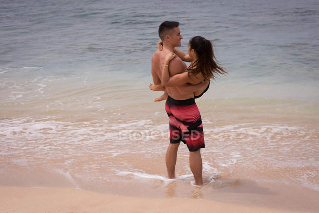 Пара розважається на пляжі в сонячний день — стокове фото