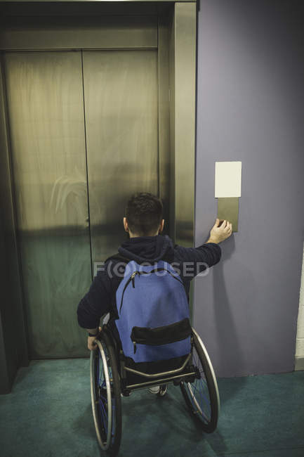Behinderter drückt Taste des Fahrstuhls in Turnhalle — Stockfoto